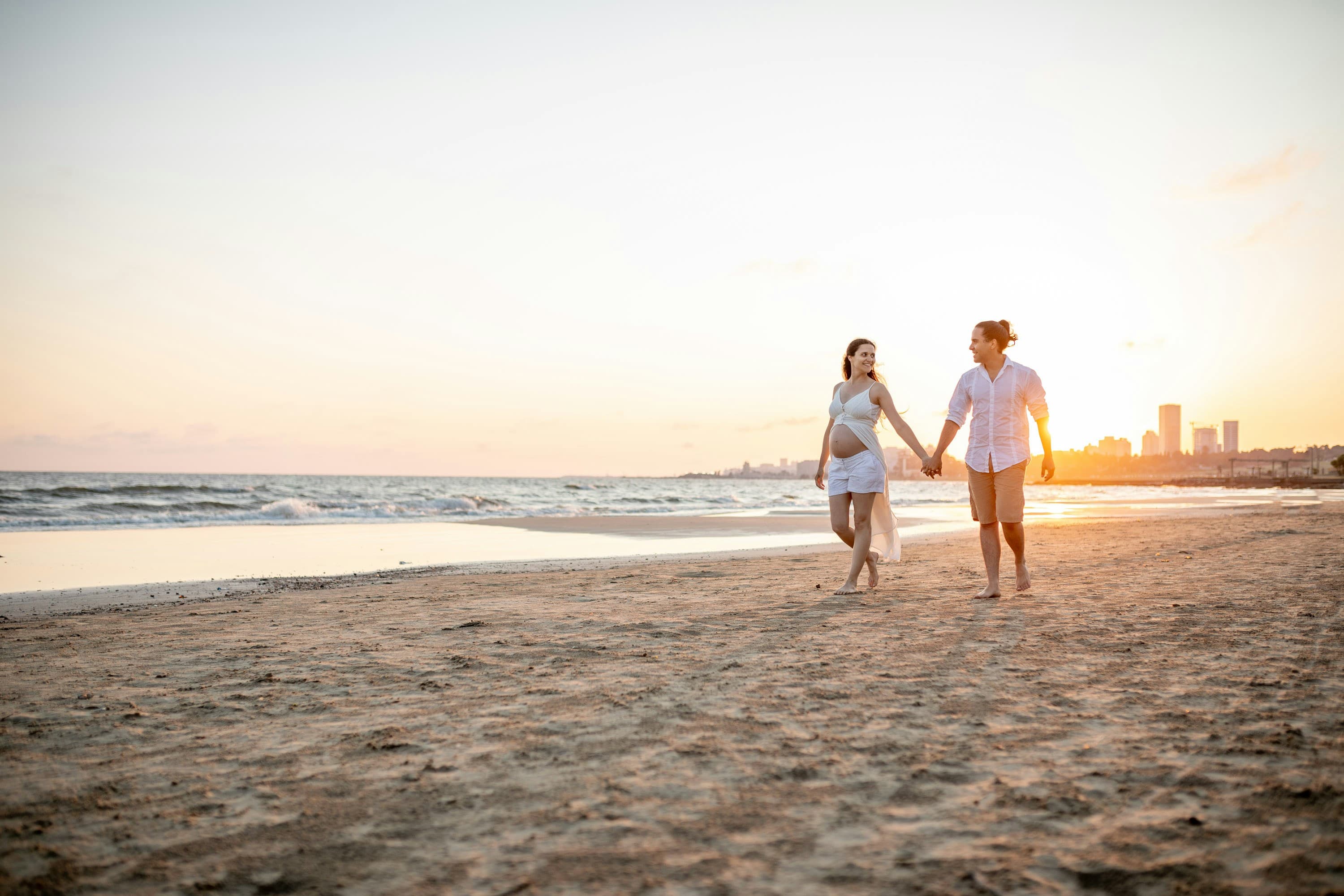 Couple walking on the beach at sunset